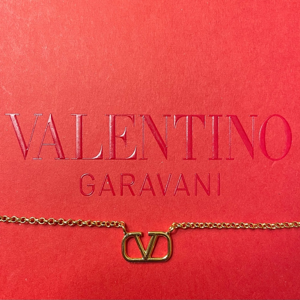 Valentino Garavani Gold V-Logo Chain Necklace on Red Background